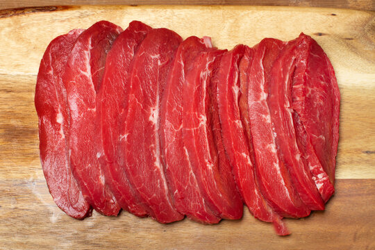 Carne vacuna en trozos sobre un fondo de madera. Vista superior y de cerca.