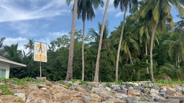 Private property sign against a background of palm trees and a blue sky