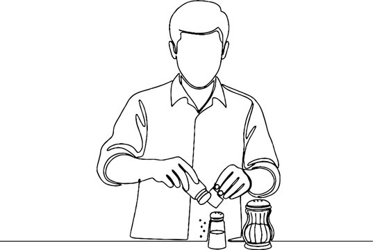 Person seasoning food with salt and pepper shakers.