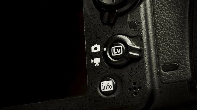 Close up of switching camera settings from photo to video mode on a DSLR or mirrorless body.