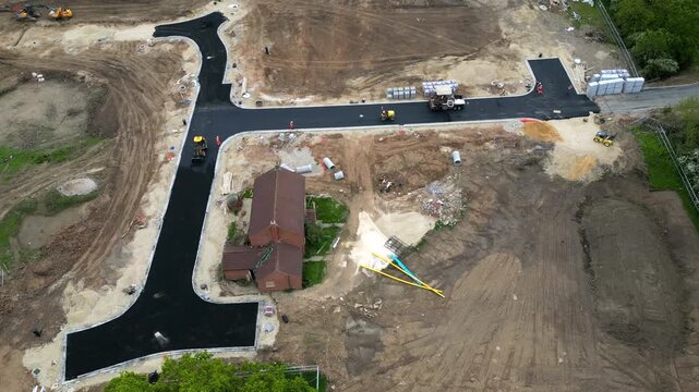 Workers are busy laying fresh asphalt and shaping the roadway at the Bellway site in Boroughbridge. Equipment and vehicles are visible as the area develops