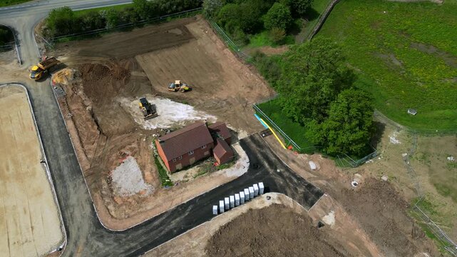 Machines operate on the Bellway site in Boroughbridge. Workers move dirt and prepare the ground. Equipment is busy shaping the area for future building
