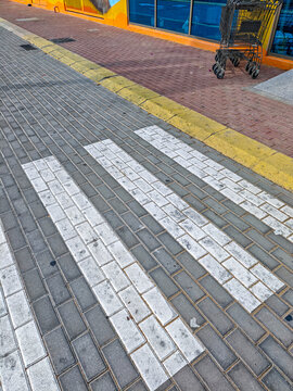 Crosswalk stripes on pavement near storefront