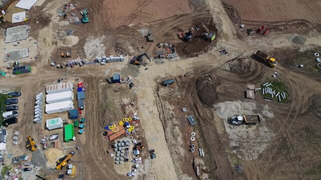 This aerial shot shows the construction site at Bellway in Boroughbridge UK. It highlights the machinery and materials set up for the ongoing building activities on site