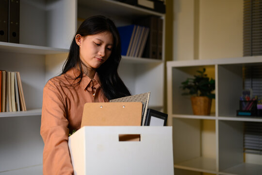 Young Asian Businesswoman Packing Personal Belongings in Box After Resignation Leaving Office Job