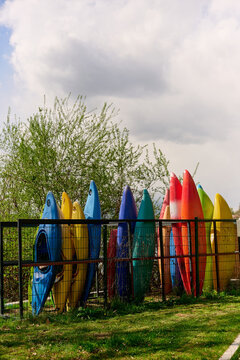 Colorful kayaks by cloudy sky