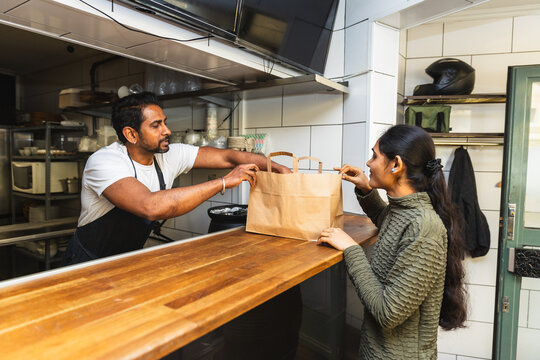 Indian man preparing paper bag with food order