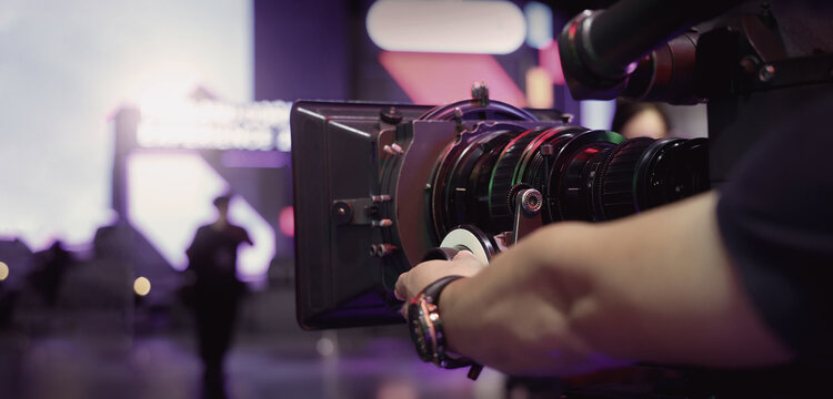 Behind the scenes of movie shooting or video production at studio with high quality camera gimbal or tripod equipment set up and professional film crew team or camera operator with flare lighting.