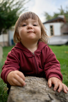 Child Playing with Log in Outdoor Space During Daylight Hours