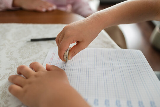 Child's hand erasing error from school notebook