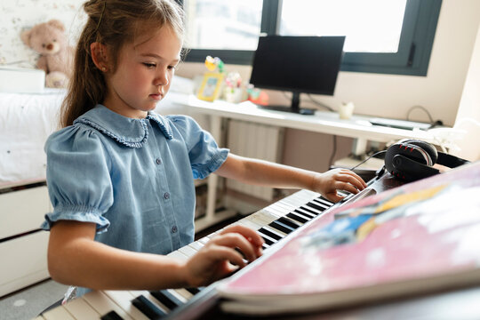 Young girl learning to play electronic keyboard