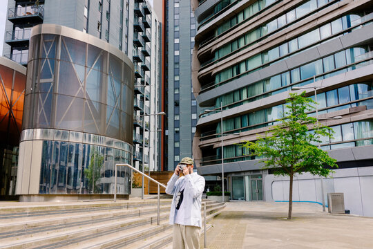 Tourist photographing corporate buildings in London's busines district