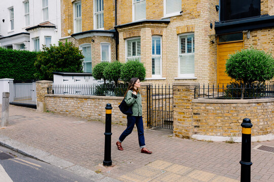 Woman moving through London streets passing house facades