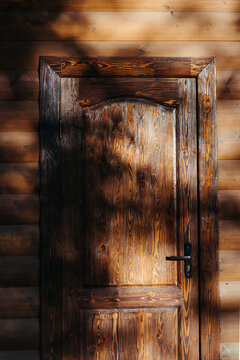 Rustic Wooden Door Framed by Sunlight and Shadows in a Quiet Retreat