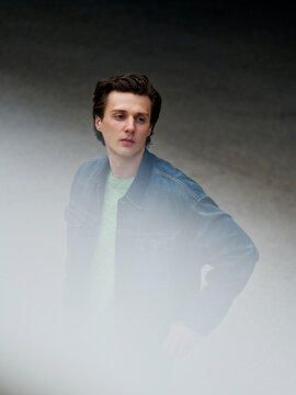 Young Man Stands in Fog at Urban Location During the Day