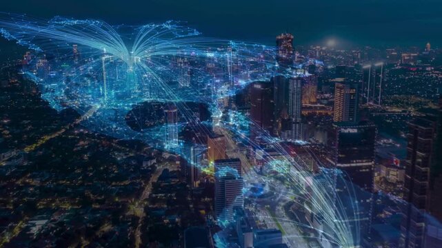 Aerial view of a metropolitan city at night with interconnected curving blue light trails above the buildings. Illustrates the concepts of a smart city, 5G networks, and digital data transfer.