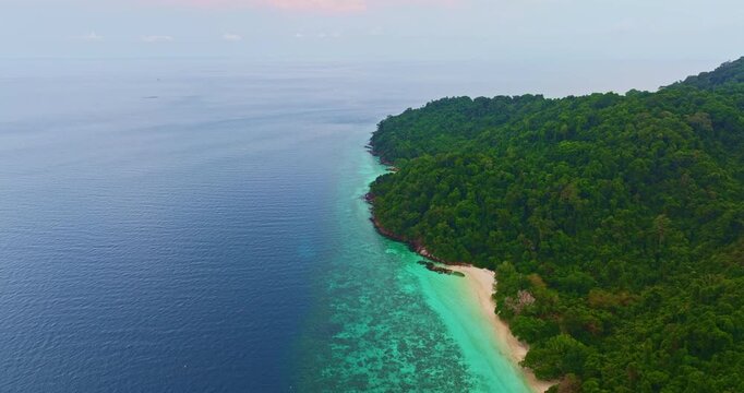 Aerial View of Exotic Beach Landscape in Phang Nga. Scenic drone panorama of a tropical coastline with crystal clear seawater and vibrant coral formations along Mai Ngam Beach, Thailand.