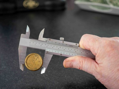 analogue vernier caliper precision engineering measurement tool  use to measure the diameter of a brass weight
