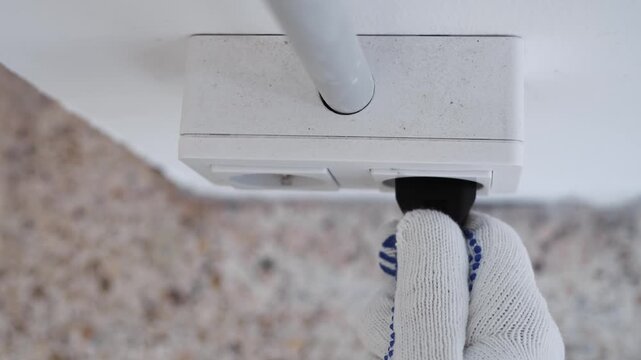 Closeup Of Skilled Electrician Securing Power Cable Into Wall Socket With Safety Emphasis