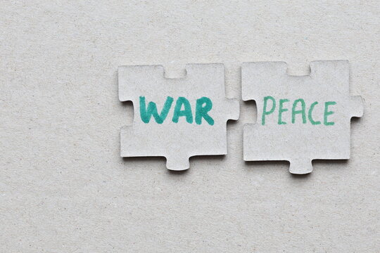 War or peace puzzle concept. Hand written gren text on gray background. Close up photo.