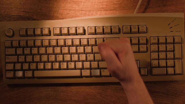 Man working and gaming on retro computer PC, IT engineer with vintage computer at home, using old fashion technology, close up of retro setup. 