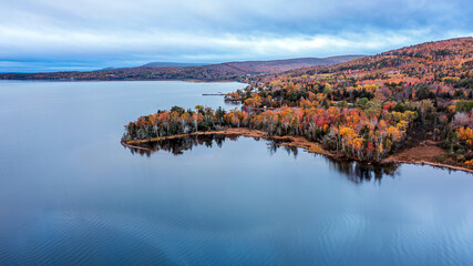 Obraz premium Autumn Coastal Landscape with Colorful Forest and Calm Waters in Nova Scotia, Canada