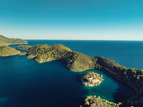 Aerial view of the monastery on St. Mary Island in Veliko Jezero lake, Mljet National Park, surrounded by pine forests and the Adriatic Sea, Dubrovnik-Neretva County, Croatia.