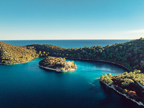Aerial view of Mljet National Park with the historic monastery on St. Mary Island, surrounded by the deep blue waters of Veliko Jezero in Dubrovnik-Neretva County, Croatia.