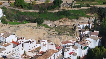 Obraz premium Aerial view of small town with white buildings and green hills