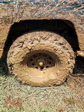Mud-covered off-road vehicle wheel after crossing an extreme muddy track, highlighting rugged adventure driving, challenging terrain conditions, and the demanding nature of off-road activities.