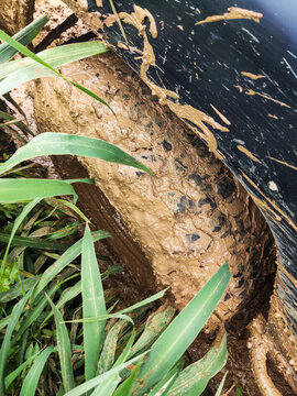 Off road vehicle tire covered in thick mud while navigating challenging hillside trail in Bogor, illustrating rugged adventure, difficult terrain, and extreme driving conditions.
