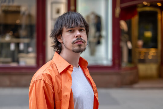 Twenty five year old young man walking along a street in the city center.