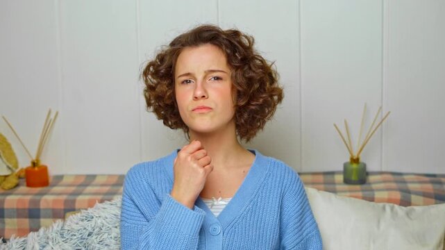 young woman with dental braces pointing at her teeth, expressing slight discomfort or self-consciousness about her orthodontic treatment at home