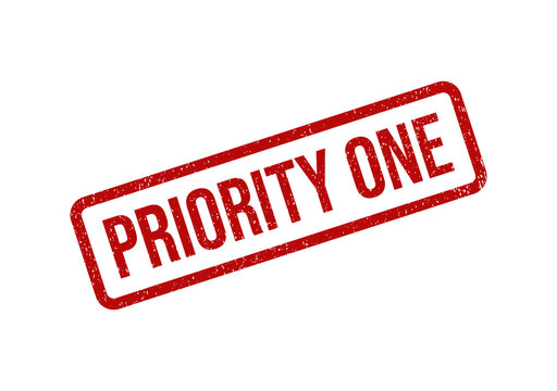 Red priority one rubber stamp ink mark on a flat surface