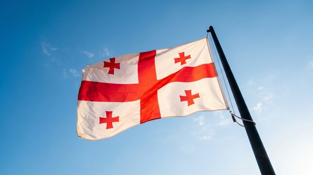 Georgian flag waving in the wind against a clear blue sky