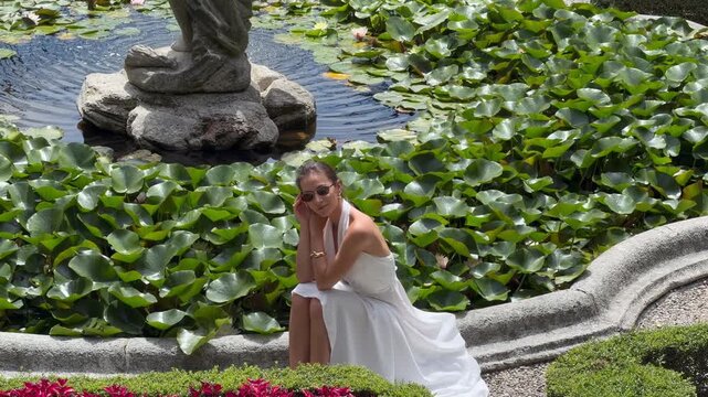 Beautiful Woman White Dress Walking Historic Italian Villa Garden Ornate Iron Gate Lake Como Italy, Cinematic Luxury Travel Wedding Fashion Lifestyle Baroque Fountain Lombardy Europe