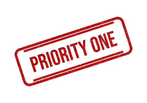 Red priority one rubber stamp ink mark on a flat surface