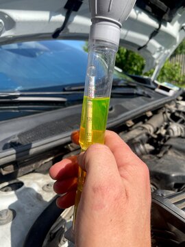 Close up of a mechanic checking car coolant density with a hydrometer tester