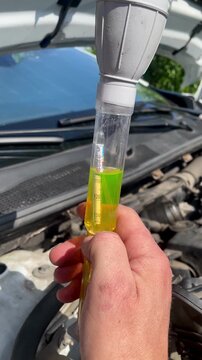 Close up of a mechanic checking car coolant density with a hydrometer tester