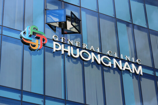 DALAT, VIETNAM - JANUARY 29, 2026: A close-up view of the General Clinic Phuongnam corporate 3D logo and sign text mounted on the glass windows of a high-rise office building.