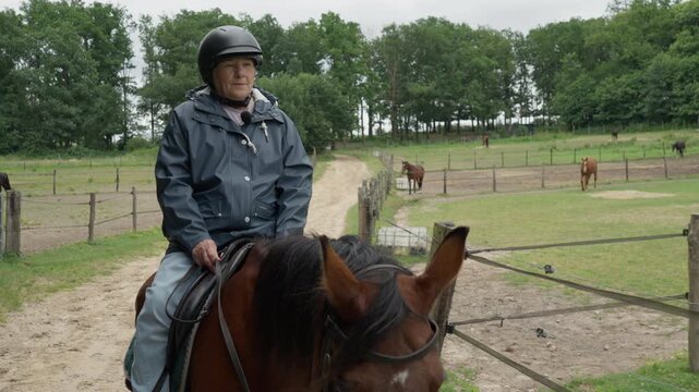 Senior pensioner enjoys horse riding holiday on country ranch pathway. Elderly lady experiences outdoor ecotourism, healthy retirement recreation, active longevity hobby, and wellness travel.