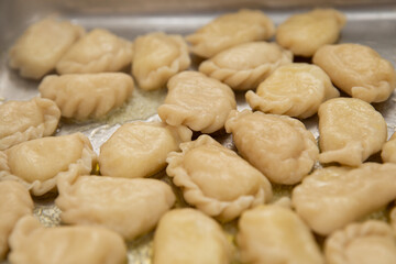 Fototapeta premium Traditional Ukrainian varenyky dumplings with butter on a metal tray, top view close-up