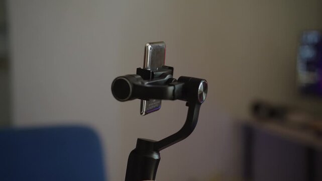 Close-up of hand turning on three axis gimbal stabilizer. Concept of device automatically calibrating its brushless motors for smooth video recording with smartphone