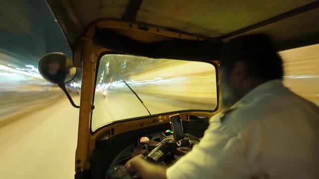 View from the cabin of an autorickshaw in Mumbai, India. Bokeh time lapse motion video of the city roads with vehicle traffic in the evening.
