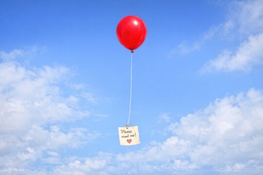 A red balloon with a sign attached, often used as a symbol of hope and attention getter