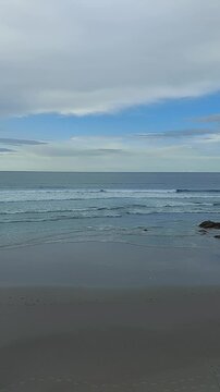 Footsteps on the seashore of Os Castros beach with calm Atlantic waves in Galicia Spain