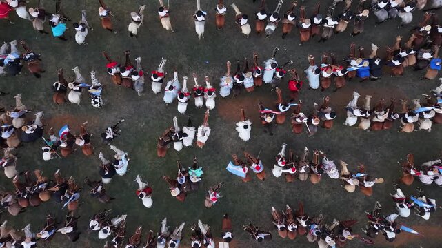 Gauchos montando caballos en fiesta popular rural vistos desde el aire, tradici&oacute;n ecuestre y cultura argentina