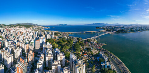 Obraz premium Aerial view from a high angle of the urban landscape of Florianópolis, with skyscrapers, public park and ocean bay.