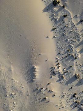 Aerial view of the sand dunes in Parque Natural Dunas de Corralejo with wind-swept patterns and sparse desert vegetation in Corralejo, Canary Islands, Spain.