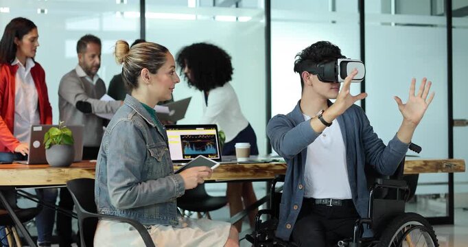latin young man in wheelchair using virtual reality glasses at office in Mexico Latin America, hispanic coworkers or teamwork in concept of disability and social inclusion using vr technology